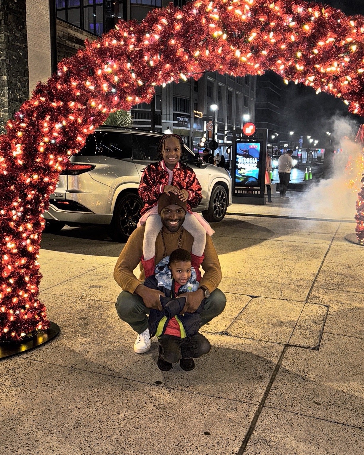 Phil BeLight with his children under holiday lights