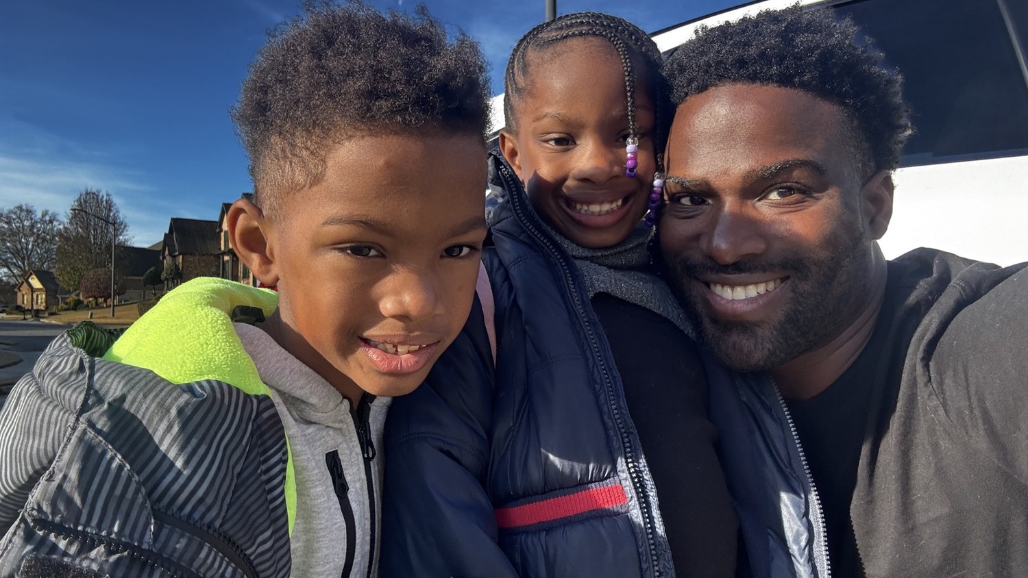 Phil BeLight smiling with his children outdoors